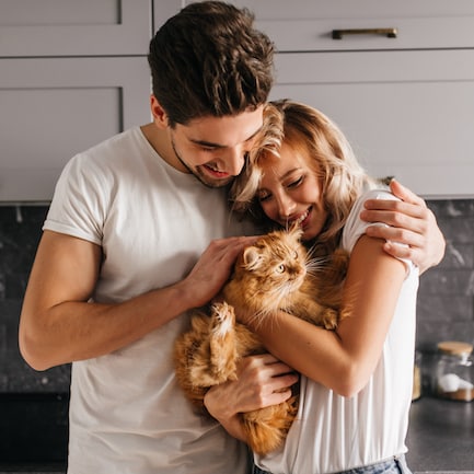 brunette-man-looking-at-his-cat-and-embracing-wife-2021